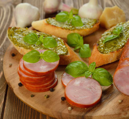 Sausage with basil on a brown background closeupの写真素材
