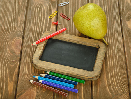 writing board and pencils on brown backgroundの写真素材