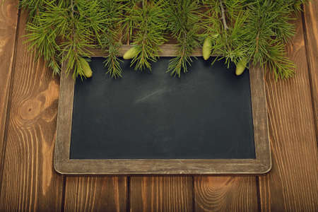 Green twigs and writing board a brown backgroundの写真素材