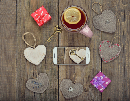 Telephone and different accessories on a wooden background, Valentine's Day concept