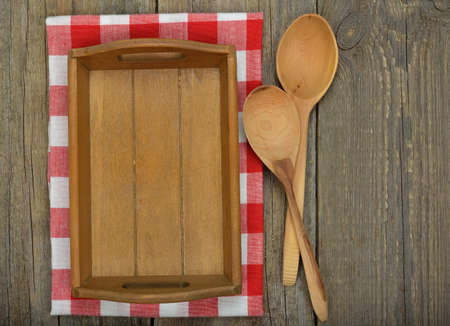 Wooden tray and spoons on a brown background