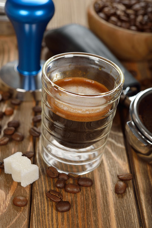 Espresso coffee in a glass cup on a brown backgroundの写真素材