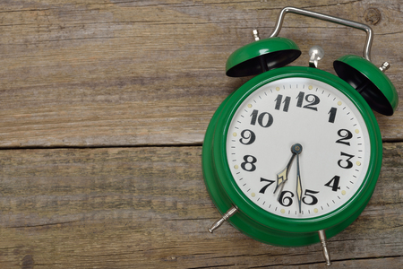 Vintage alarm clock on a wooden backgroundの写真素材