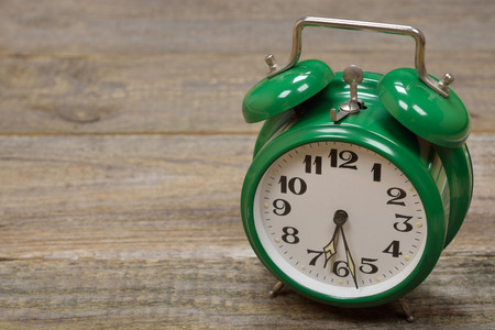 Vintage alarm clock on a wooden background