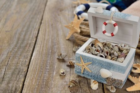 Seashells in a wooden box on a brown backgroundの写真素材