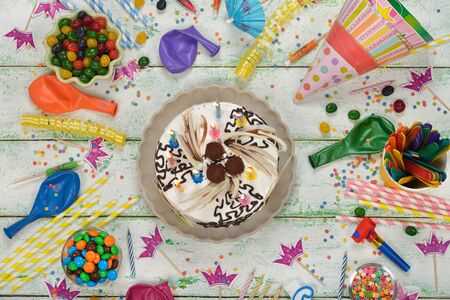 Birthday cake and various accessories for the holiday on a white backgroundの写真素材