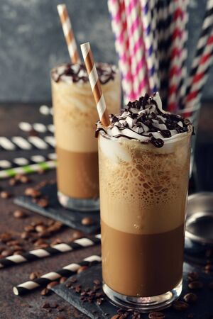 Cold frappe coffee with cream on a gray background