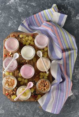 Various natural yogurts in glass jars on a gray backgroundの写真素材