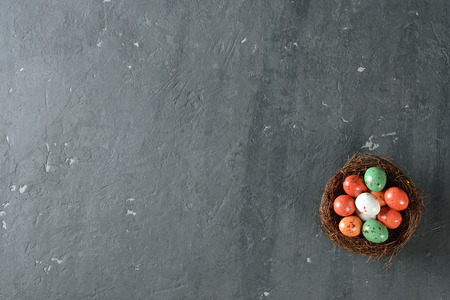 Decorative easter eggs in a nest on a gray backgroundの写真素材