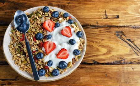 Muesli with yogurt and berries on a brown backgroundの写真素材