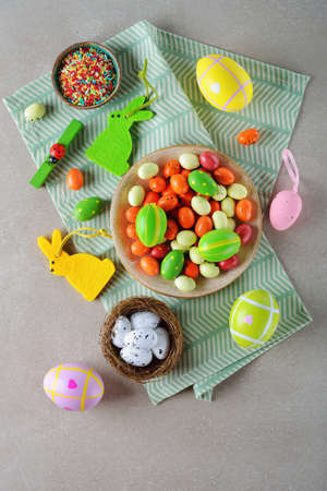 Various Easter decorations and sweets on a gray background