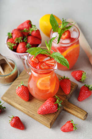 Refreshing summer lemonade with strawberry and lemon on a gray backgroundの写真素材