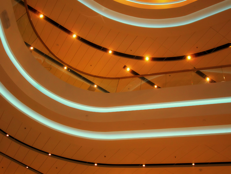 Light bulbs on the ceiling of Central Department store (TSUM). Ceiling lights. Background consists of a bright orange and blue curved lines with lamps. Kiev, Ukraine.の写真素材
