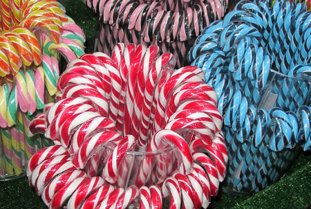 Sweetmeats. Christmas fair. Candy cane consists of blue, red, white, orange, yellow, pink, green, black sweets. Color palette.の写真素材