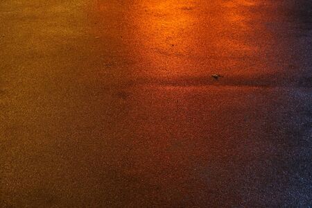 Asphalt road texture with red lights. Red water reflection on the road. Night city red lights. Asphalt street construction. City night road rflection.の写真素材