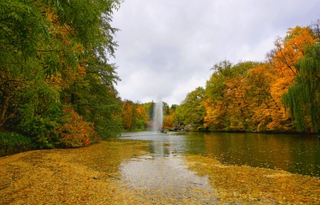 Park Sofiyivka (Sofievka), Uman', Cherkasy region, Ukraine. Golden autumn, the trees are covered with yellow, red, green leaves. Fountain of the snake. Water reflection in pond.の写真素材