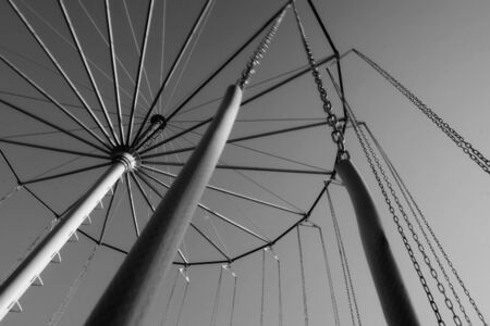 Black and white silhouette of a carousel on a chain. From below up looks the person who rolls. Black...