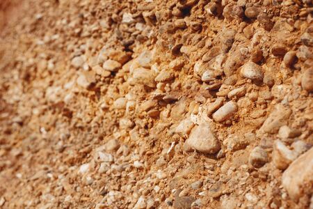 Bright sandy yellow orange red dune (rock, hill) under blue sky with white grey cloudsの写真素材