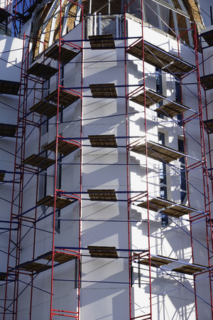Construction of a new church in a modern style. Scaffolding around the white walls of the church. New project.の写真素材