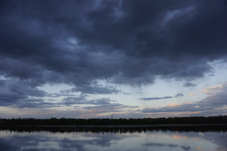 Bridge construction with reflection in river Dnieper, Kiev, Ukraine. Ukrainian landscape, Dnipro, Kyiv. Stormy dark blue clouds.の写真素材