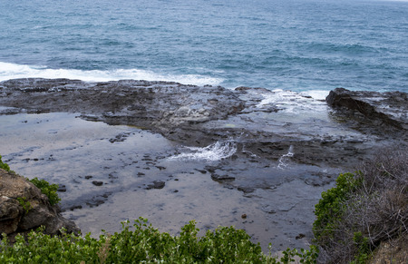 Coastal landscape with sea waves and large boulders on beach