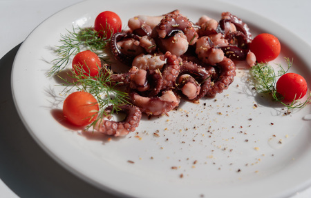 fried in olive oil, octopus tentacles with cherry tomatoes and spicesの写真素材