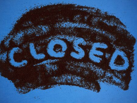 Word Closed hand written on roast ground coffee on a blue background top view. Can be used as creative Closed sign for coffee shops, cafes and bars.の写真素材