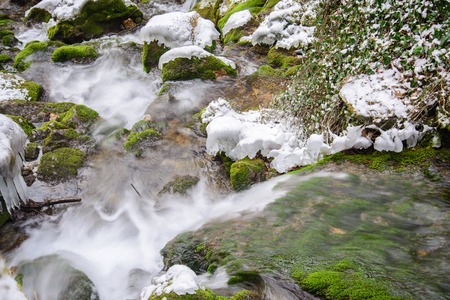 Mountain river running through stone thresholds of winter in  mountainsの写真素材