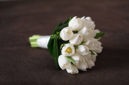 Bouquet of white tulips on a brown textile background. Side view.の写真素材