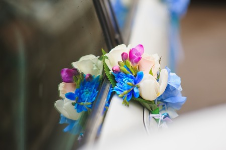 Wedding car handle decorated with white, blue, red flowers and ribbons.の写真素材