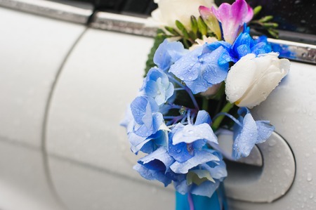 Wedding car handle decorated with white, blue, red flowers and ribbons.の写真素材