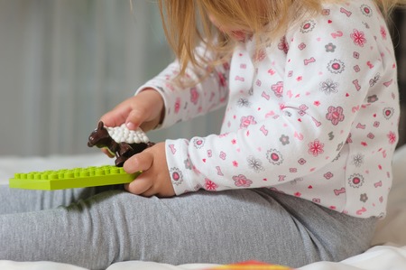 Cute cheerful child play with colorful toys at home.の写真素材