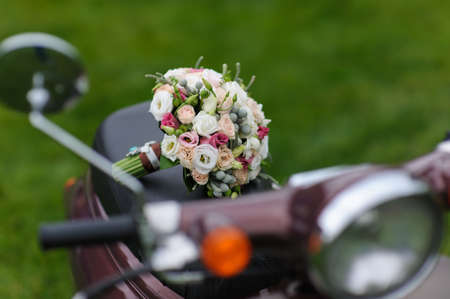 Beautiful wedding bouquet on scooters. Front view. Green lawn in the backgroundの写真素材