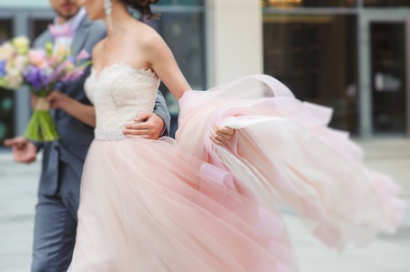 Luxury bride holding a flying dress and walkingの写真素材