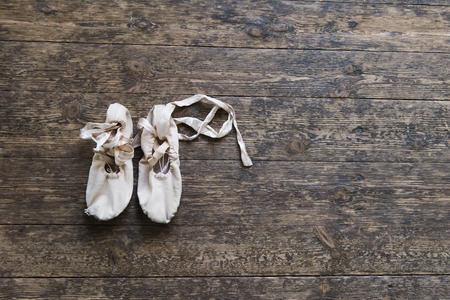 Old ballet shoes on old wooden floor. Pink ballet pointe.の写真素材