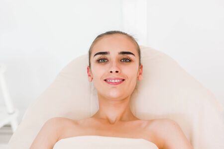 Facial massage beautiful girl. Portrait of a girl in a massage parlor.の写真素材