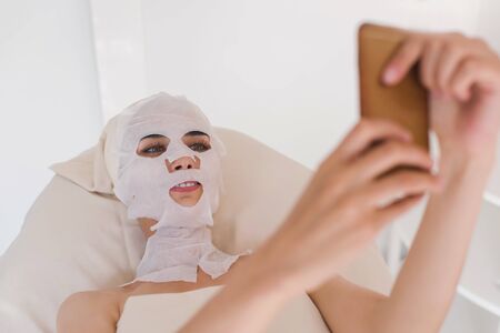 Woman with facial mask making selfie