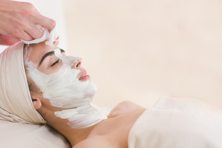 Facial mask removing at beauty salon. Spa beauty organic facial mask.