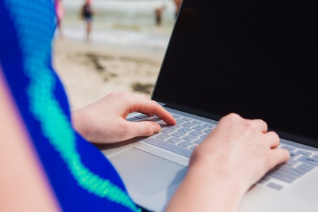Woman with laptop on the beachの写真素材