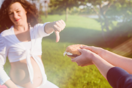 Pregnant woman refuse burger.の写真素材