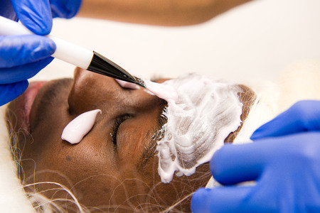 Black santa claus in beauty spa. Spa facial mask application. close-up