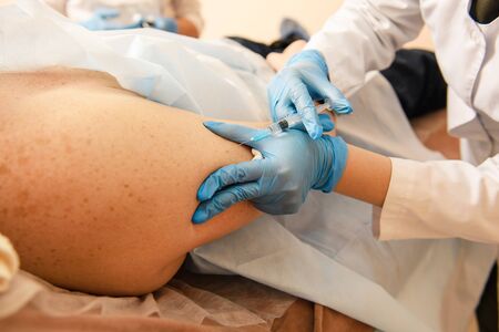 Close-up of human hands making injection with syringeの写真素材