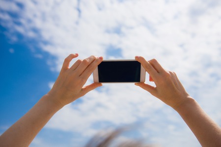 Female hands hold mobile phone