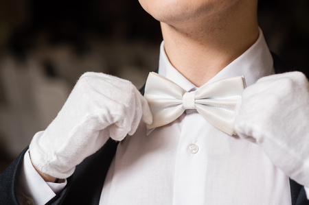 Gentleman touch his white tie bowの写真素材