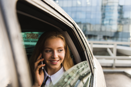 Girl with mobile phone smile in carの写真素材