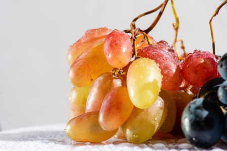 Bunch of delicious red yellow grapes indoors