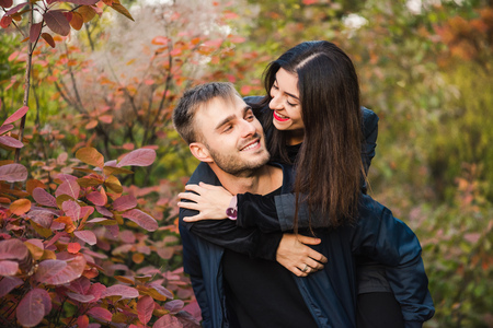 Happy young couple walk in autumn forest