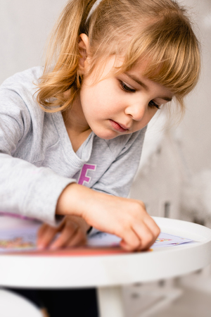 Small girl with coloring book and pencilsの写真素材