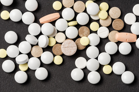 Heap of colorful medication on black background.の写真素材