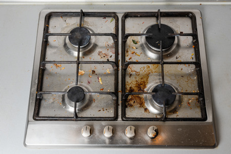 Dirty gas stove in the kitchen, top view. Gas stove with food remnants.の写真素材